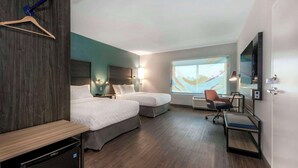 Une chambre d’hôtel avec deux lits, un bureau, une chaise, une télévision et une grande fenêtre donnant sur un beau paysage.