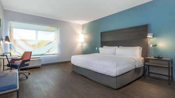 Et moderne hotelværelse med en stor seng, et skrivebord og en stol.