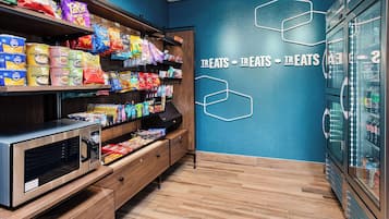 A snack display with various packaged foods and a microwave.