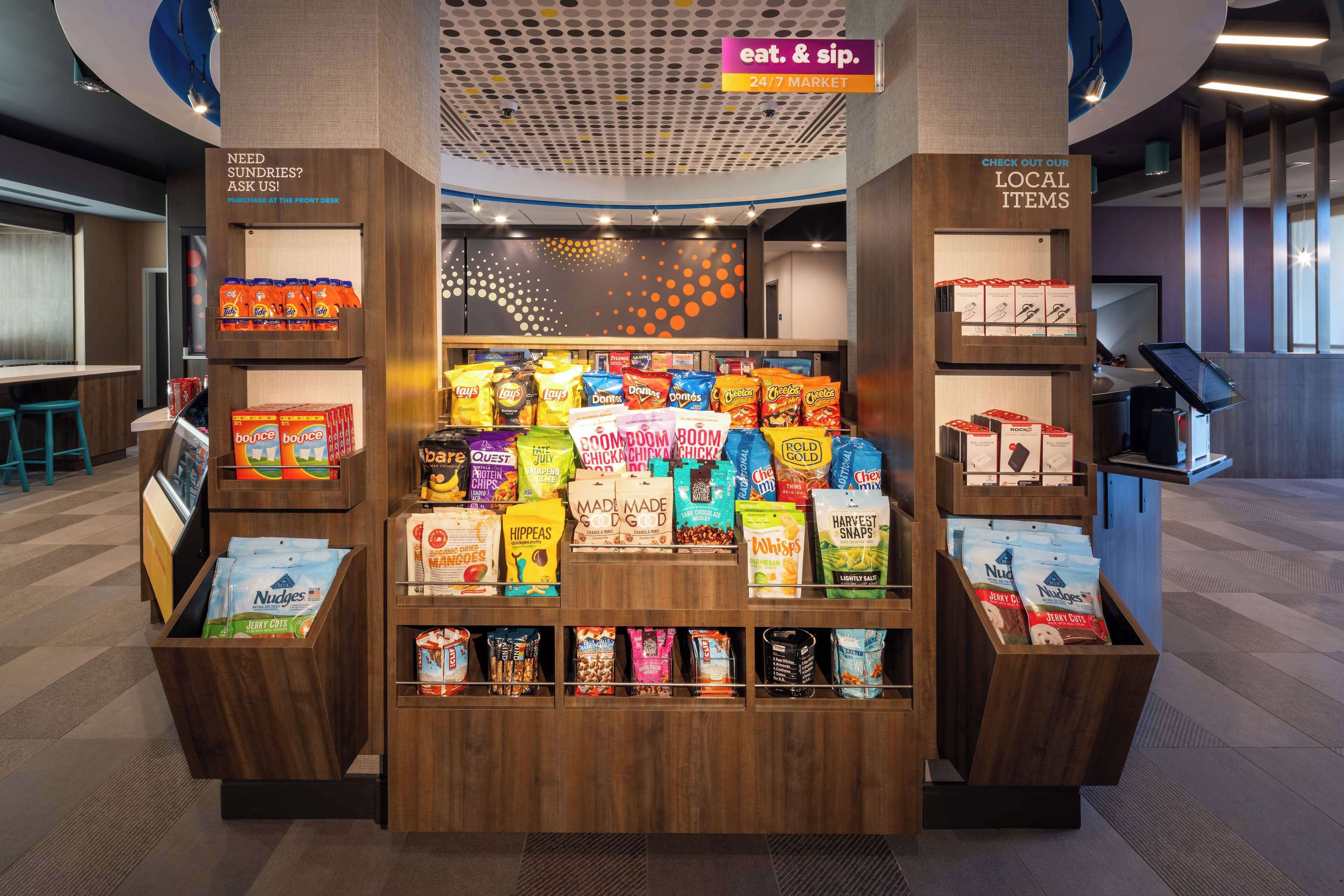 A snack display in a 24/7 market area with various packaged snacks and beverages.