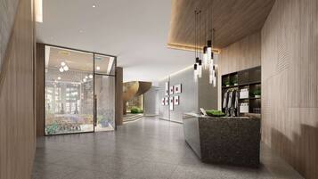 A modern lobby with a reception desk, wooden paneling, and hanging pendant lights.