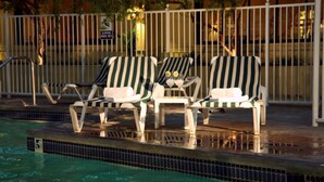 A poolside area with lounge chairs and a tiled pool edge.