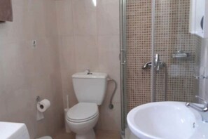 A bathroom with a toilet, a sink, and a shower enclosure. - 5 minute walk down to the historic village of Gavalochori. (Gavalochori)