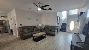 Een moderne woonkamer met een modulaire bank, een salontafel en een plafondventilator.