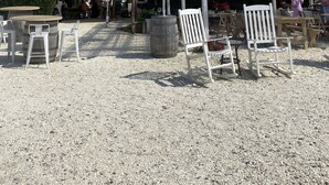 An outdoor seating area with tables and chairs, a white pergola, and a tent. - Cape Cod Retreat - Sleeps 6 - A/C & Outdoor Shower (Falmouth)