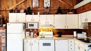 A rustic kitchen with wooden walls, white cabinets, and a wooden ceiling. - Cozy 3BR Ski-Chalet Style Retreat w/ Sauna + Fireplace— Outdoor Adventure Base (Bessemer)