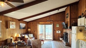 A cozy cabin-style room with a wooden interior, a fireplace, a dining area with a wooden table, and a seating area with a sofa and chairs. - Cozy 3BR Ski-Chalet Style Retreat w/ Sauna + Fireplace— Outdoor Adventure Base (Bessemer)