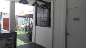 A room with a large window, a door with a sign, and a counter with baskets.