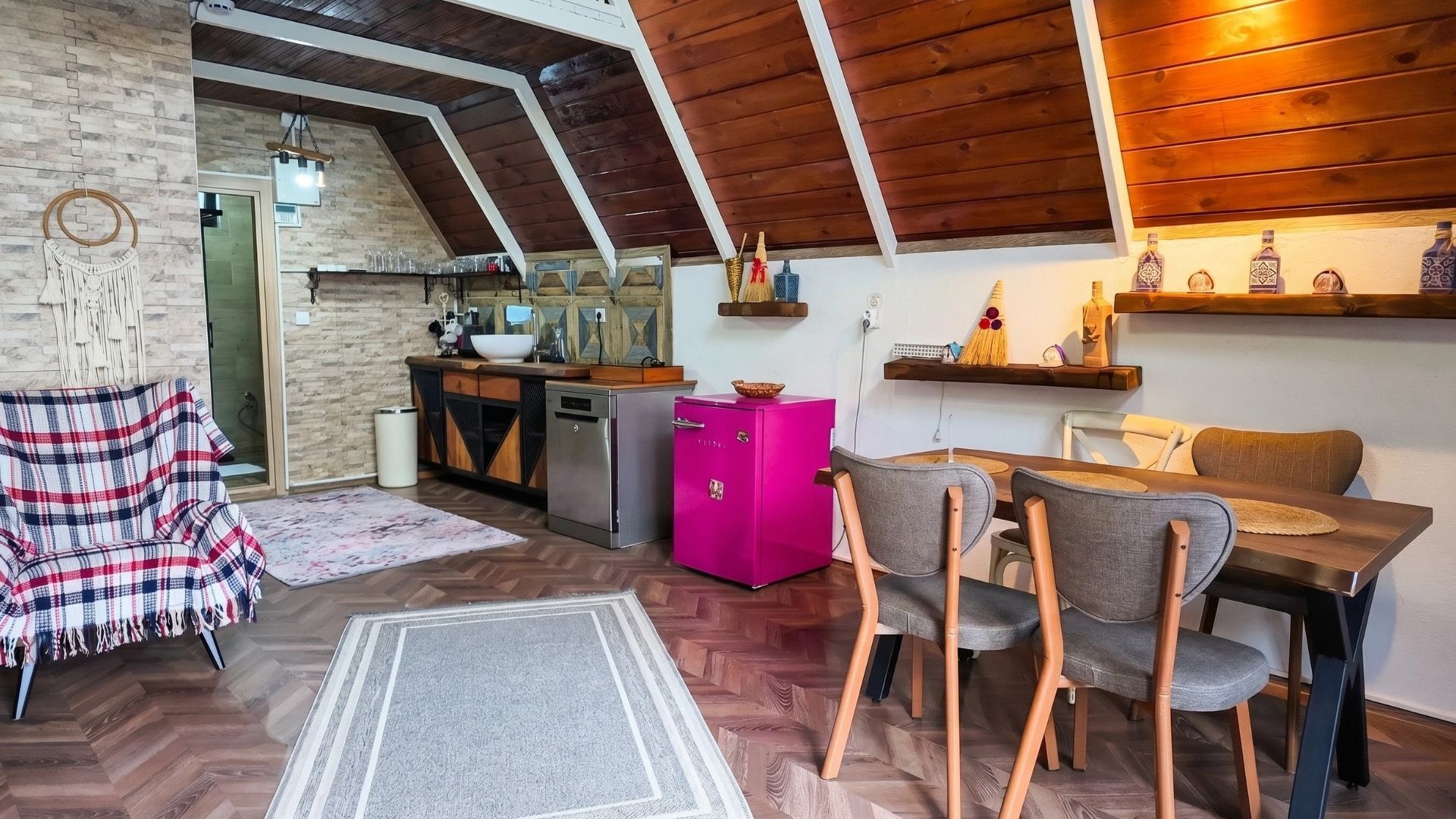 Un espace de vie chaleureux de style loft, comprenant une cuisine, un coin repas et une chambre située en mezzanine.