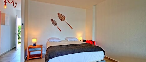 A bedroom with a bed, bedside tables, and wall art.