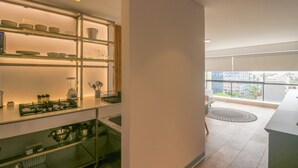 Eine moderne Küche mit Glastrennwänden, einem Gasherd und Blick auf die Stadt durch große Fenster.