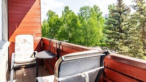 A wooden deck with a chair and a table, overlooking a forested area. - Perfect apartment near the beach + 6 free bikes (Pärnu)