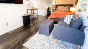 A modern bedroom with a large bed, a sofa, a TV, and a ceiling fan. - Private Dallas/Bishop Arts Retreat  (Dallas)