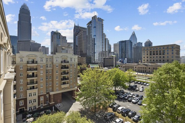 A high-rise building with a modern design, surrounded by other tall buildings and a parking lot with cars. - Beautiful Blue | Spacious, Free Parking, View, Gym (Charlotte)