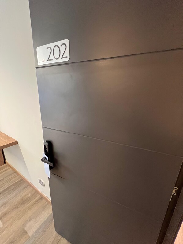 A door with a number plate '202' indicating a room number.