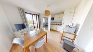 A modern kitchen with white cabinets, a microwave, and a toaster. - Appartement L'escalade Marine (Ouistreham)