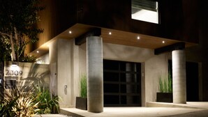 Una casa moderna a due piani con tetto piatto, ampie finestre e un garage.