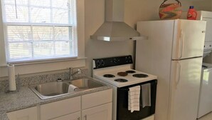 A compact kitchen with a stove, sink, and refrigerator. - The Alexandria House #3
 (Jackson)