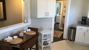 A compact kitchen with white cabinets, a dining table with chairs, and a coffee maker. - The Alexandria House #3
 (Jackson)