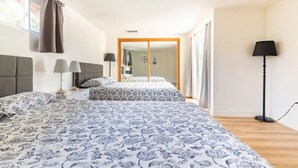 A bedroom with two beds, a large mirror, and a floor lamp. - Family Vacation Home, Spa & Big Pool, Game Room, 8 minutes to Disney✨ (Anaheim)