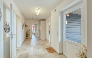 Stylish hallway leads to a cozy bedroom with a large window and comfortable bed.