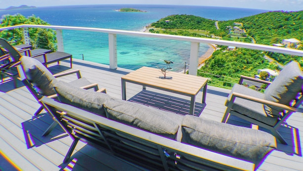 A balcony with outdoor furniture, a view of the ocean, and a distant island. - NEW LISTING!! The ULTIMATE Sunrise Retreat! (St. John)