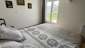 A bedroom with a large bed, a skylight, and a view of the outdoors.