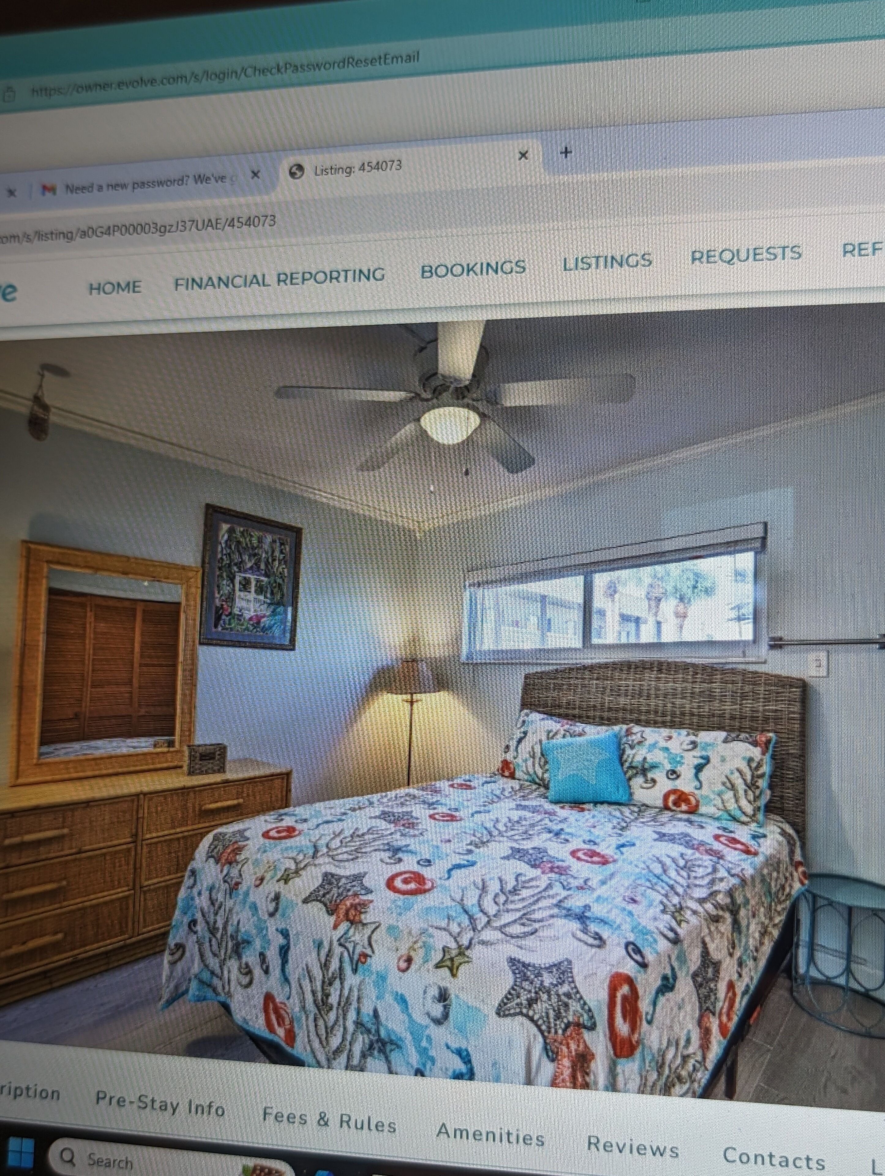 A bedroom with a bed, a window, a ceiling fan, and a wooden dresser.