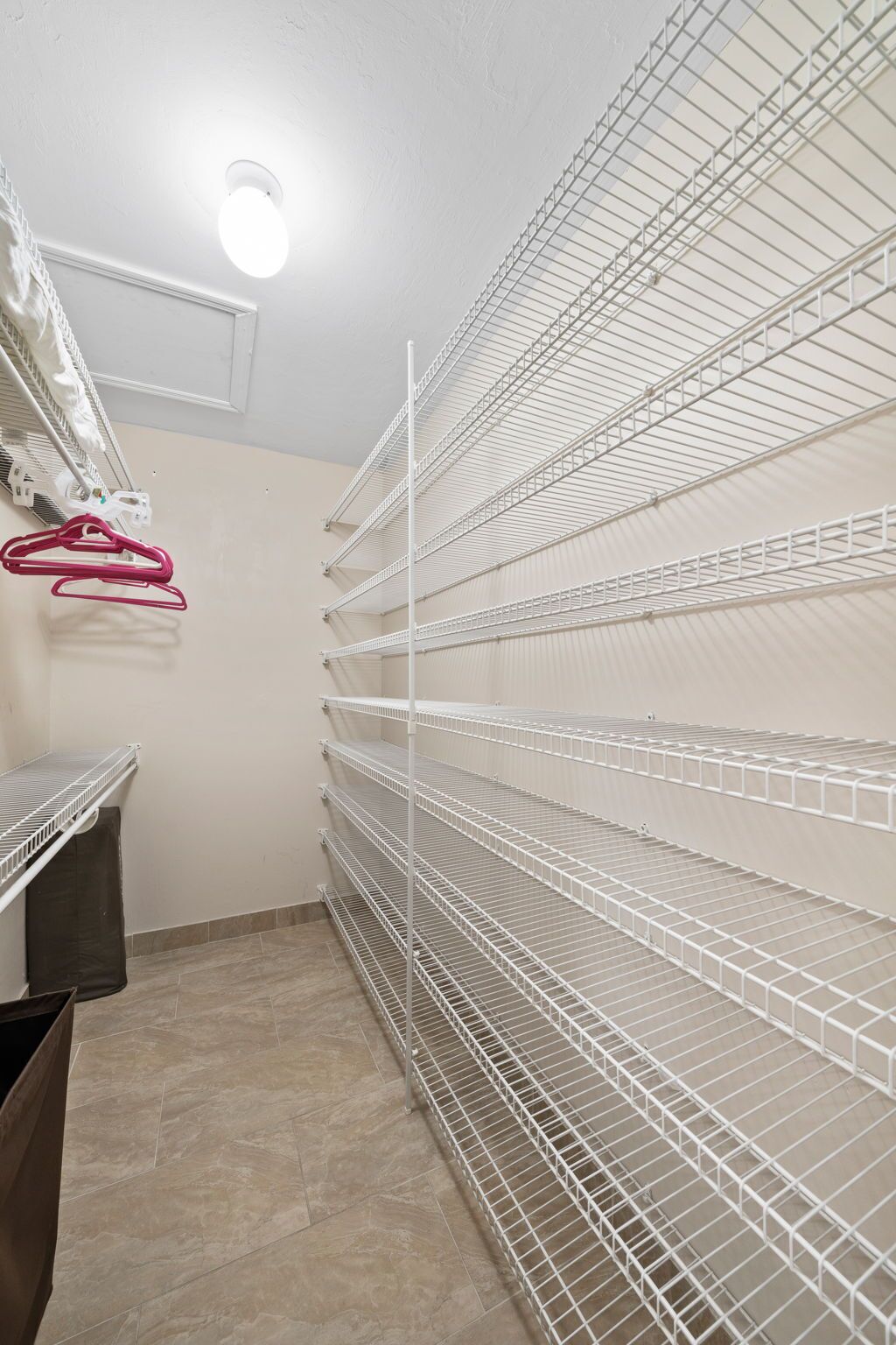 A storage room with metal shelving units and a ceiling light fixture.