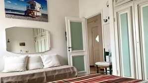 Ein Schlafzimmer mit Bett, Stuhl, Tür und Spiegel.