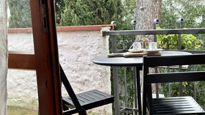 Ein Balkon mit Tisch, Stühlen und Blick auf Bäume und ein Gebäude.