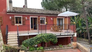 A two-story building with a balcony, outdoor seating, and a small garden area. - S333 – Sirolo, three-room apartment with terrace and parking space (Sirolo)