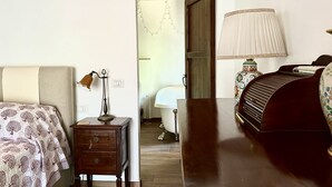 A bedroom with a bed, bedside table, lamp, and a wooden door leading to a bathroom. - S333 – Sirolo, three-room apartment with terrace and parking space (Sirolo)