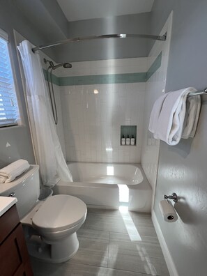 Ein modernes Badezimmer mit Toilette, Badewanne und Dusche.