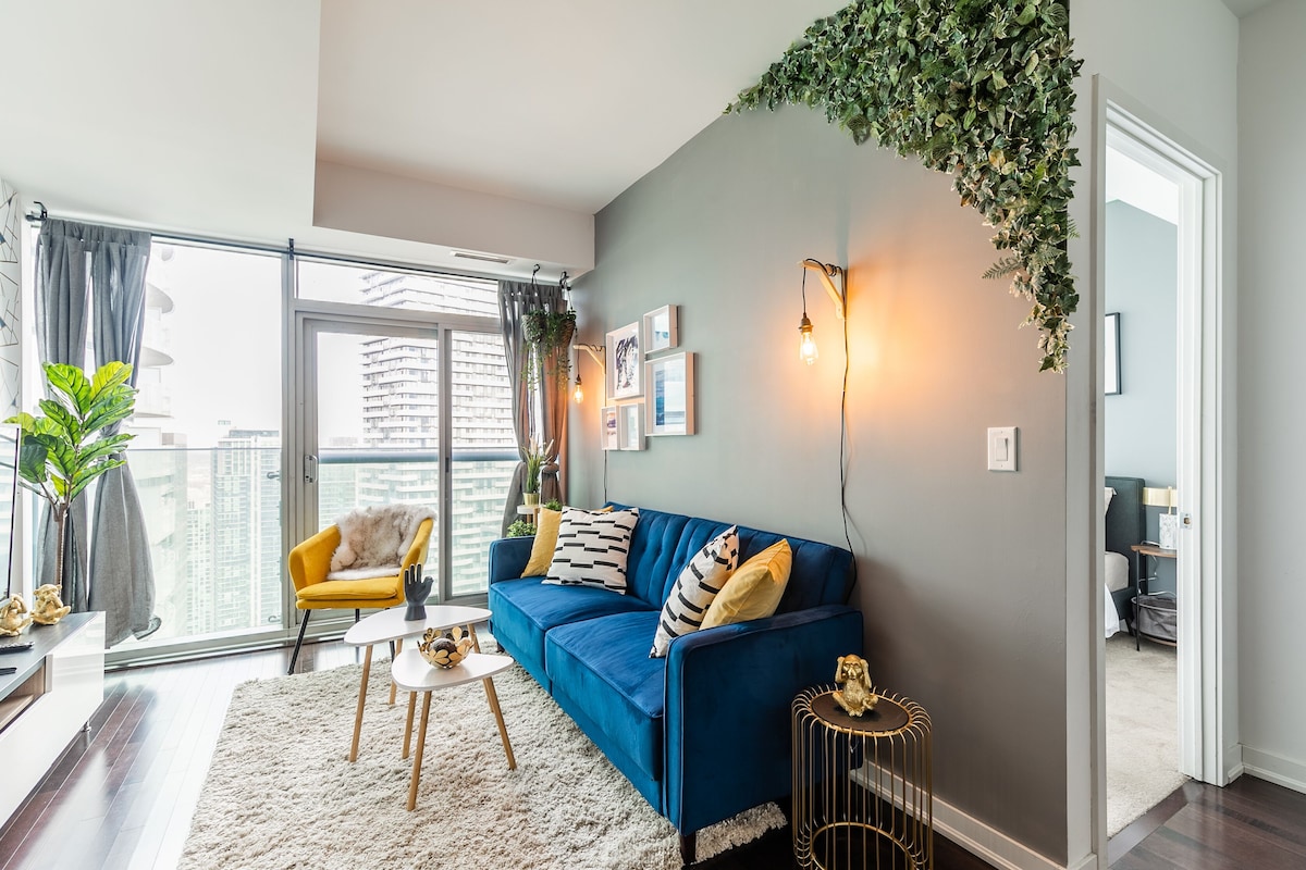 A modern living room with a blue sofa, a yellow armchair, and a white coffee table.