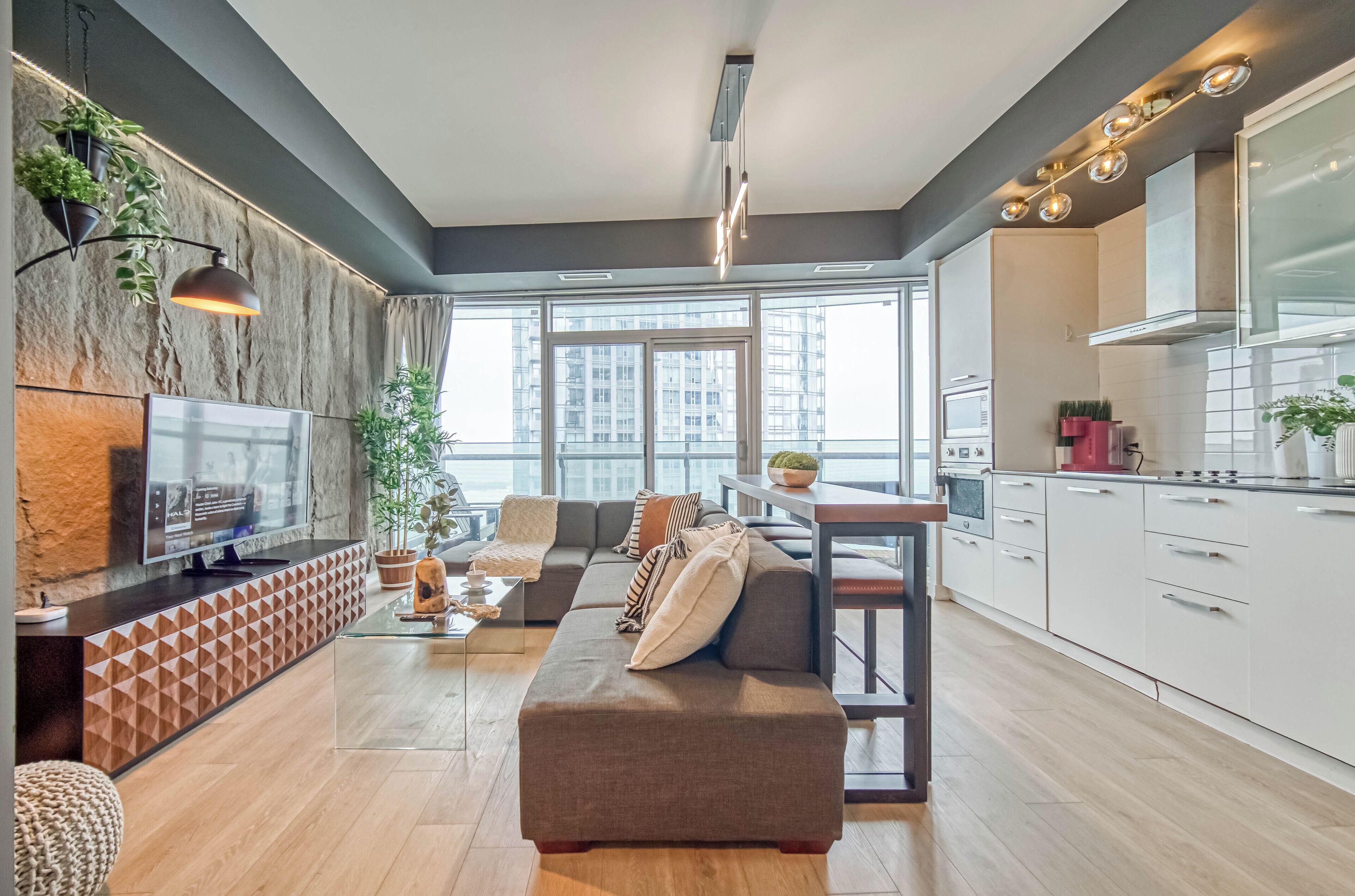 A modern living room with a sofa, TV, and dining area.