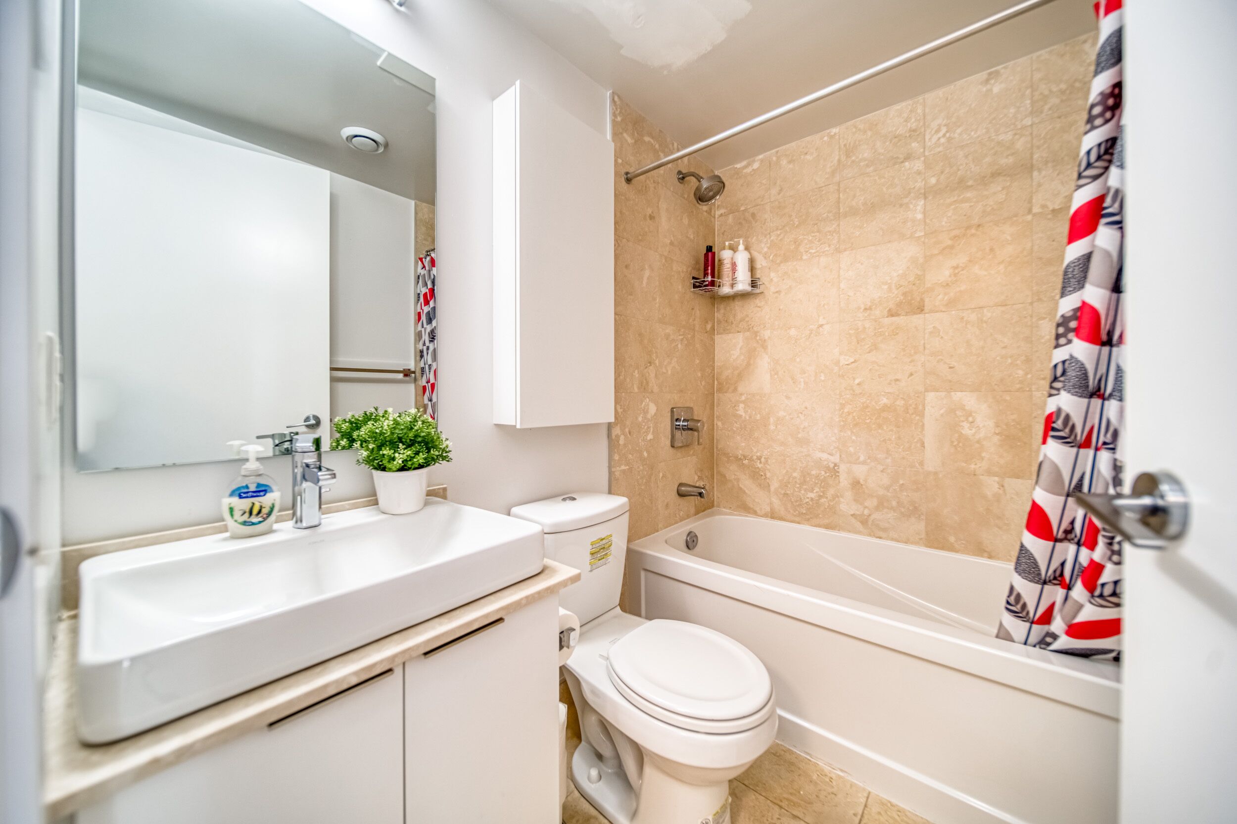 Een moderne badkamer met een witte wastafel, toilet en bad.