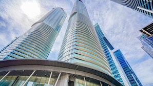 Two tall, curved skyscrapers with reflective glass facades and a curved building in the foreground. - SkyTree Modern Suites (Toronto)
