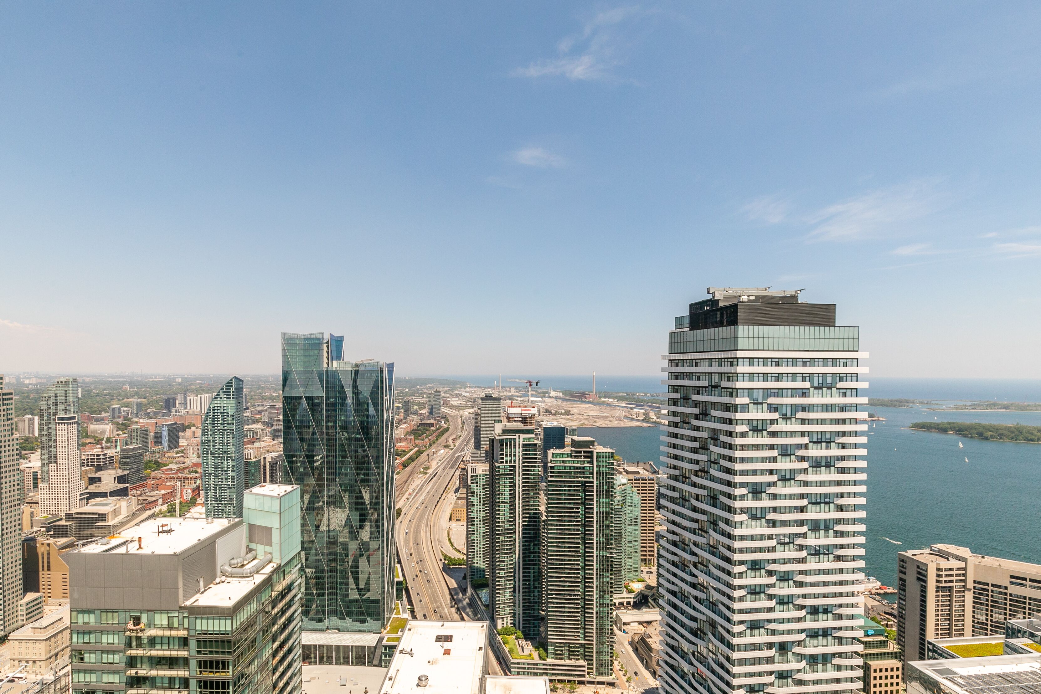Un immeuble de grande hauteur doté d’une façade moderne en verre, entouré d’autres bâtiments imposants et offrant une vue sur la côte.