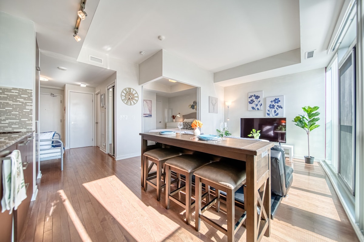 A modern kitchen with a wooden countertop, bar stools, and a dining table.