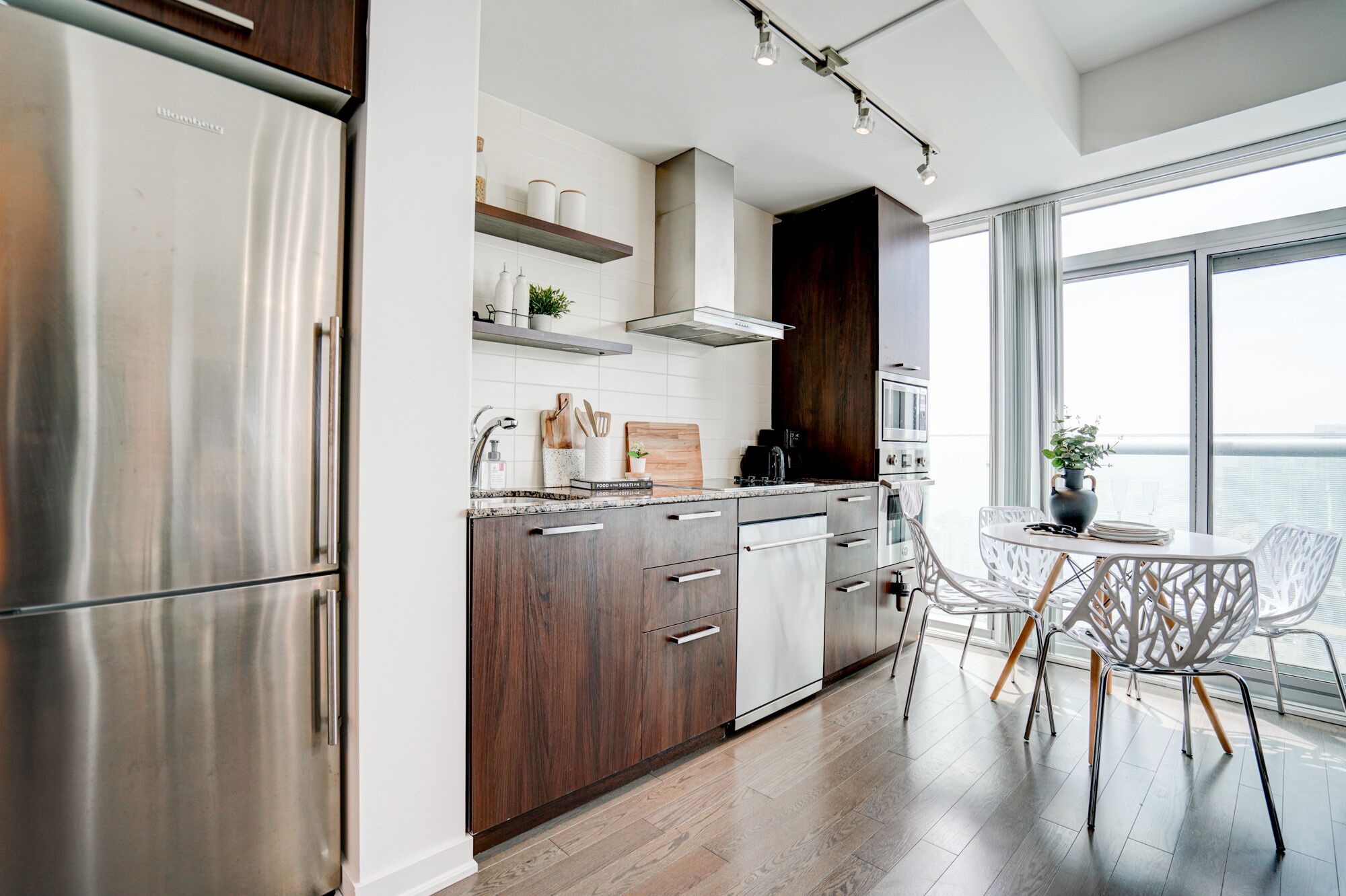 Una cocina moderna con electrodomésticos de acero inoxidable, armarios de madera y un comedor con vistas.