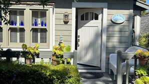 A house with a front door, a mailbox, and a small porch with a chair. - Charming Cottage in Carmel-by-the-Sea. Blocks from downtown and the beach! (Carmel-by-the-Sea)