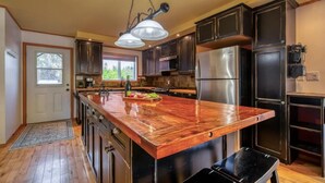 Una cucina moderna con una grande isola, elettrodomestici in acciaio inossidabile e mobili scuri.
