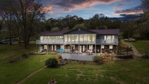 A two-story house with a large front porch and a swimming pool. - Welcome to our lake house on the beautiful Hiwassee River! (Calhoun)