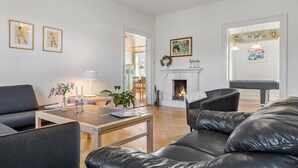 Ein Wohnzimmer mit Kamin, Billardtisch und einer Ledersofa.