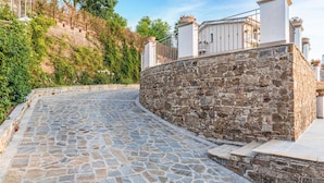 A stone-paved pathway leading to a stone wall with a metal railing. - Amazing home in Laureana Cilento (Laureana Cilento)