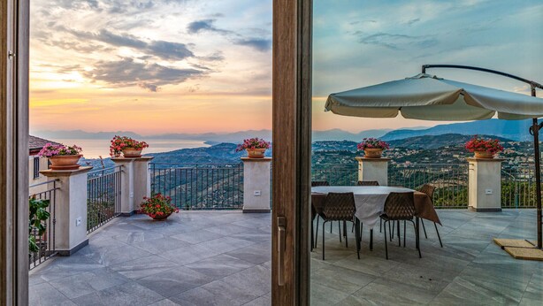 A terrace with a table and chairs, potted plants, and a view of the sea and mountains. - Amazing home in Laureana Cilento (Laureana Cilento)