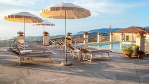A rooftop pool area with lounge chairs and umbrellas, a pool, and a view of the city and mountains. - Amazing home in Laureana Cilento (Laureana Cilento)