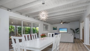 A spacious dining area with a white table and chairs, a ceiling fan, and a view of the outdoors. - Gorgeous Grove Contemporary Family Home (Sarasota)
