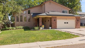 A two-story house with a garage, a covered front porch, and a well-maintained lawn. - Stylish 4 level home in a quiet safe neighborhood nestled in a cul-de-sac.  (Pueblo)